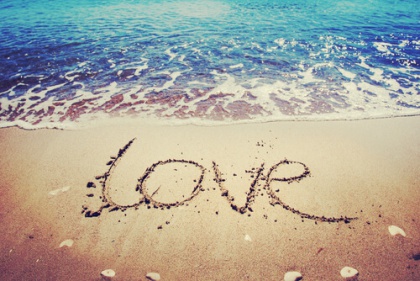 "Love" skrevet i sand på strand