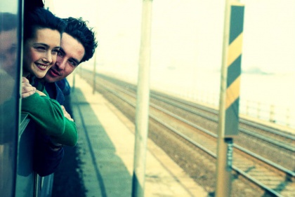 Et par stikker hovederne ud af vinduet på et tog