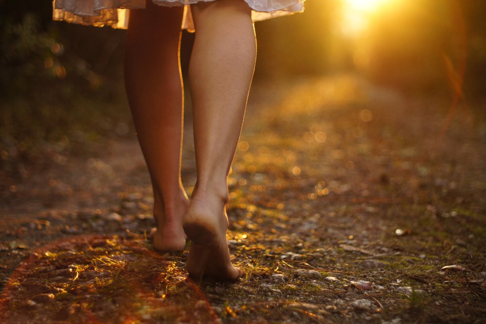 Kvinde går barfodet mos solen og væk fra sin sorg
