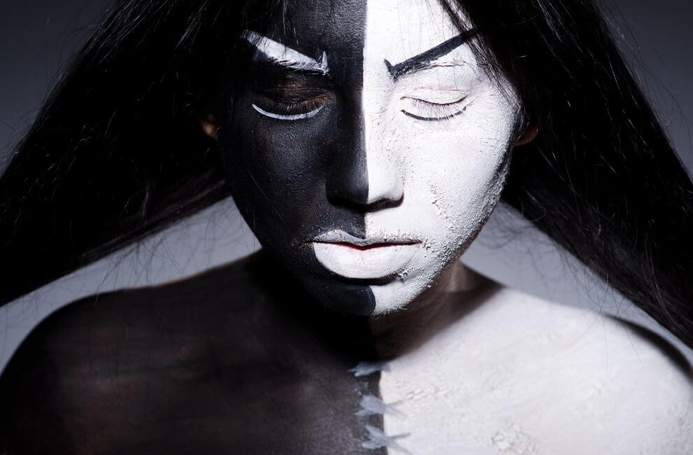 En kvindes ansigt er malet sort og hvidt for at vise hendes ego