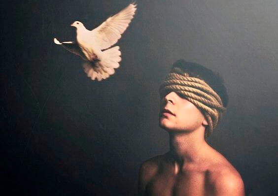 En mand med bind for øjnene og en flyvende, hvid due