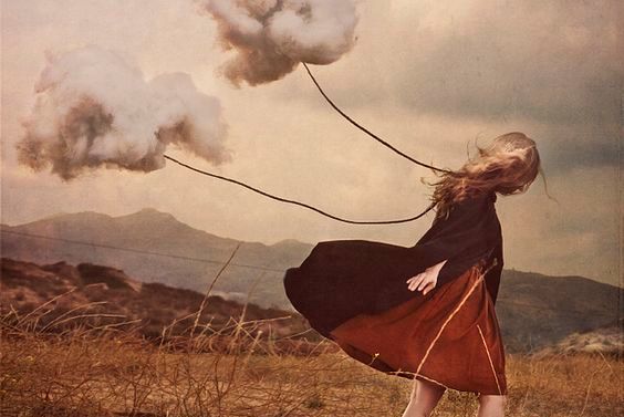 Trist pige går med skyer bundet fast i en snor