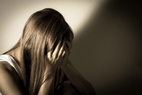 Kvinde gemmer ansigt i sine hænder