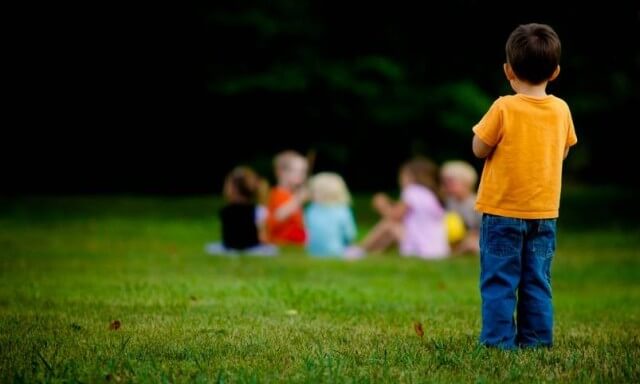 Børn leger, dreng står udenfor vennekredsen