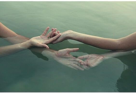 Hænder rører ved hinanden i vand