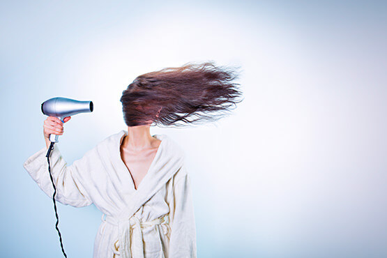 Kvinder blæser sit hår med en hårtørrer
