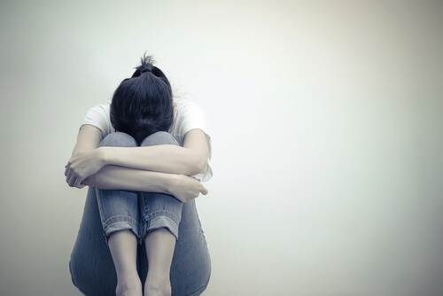 Kvinde sidder sammenkrummet på gulv i frustration over at have en dårlig psykolog