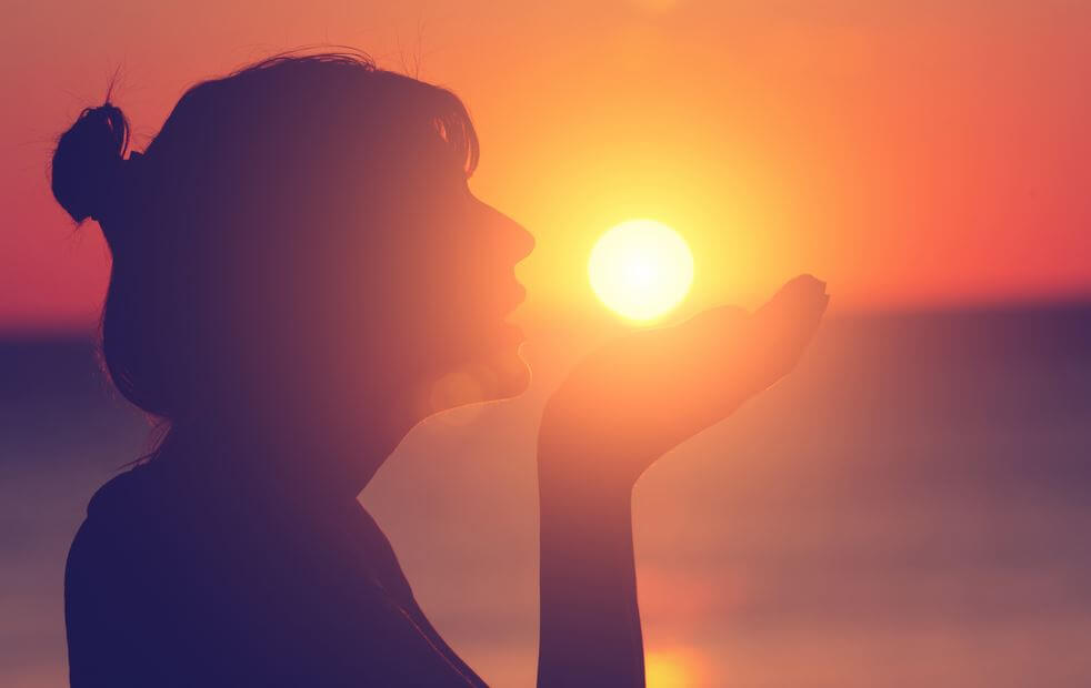 Kvinde kysser mod solnedgang