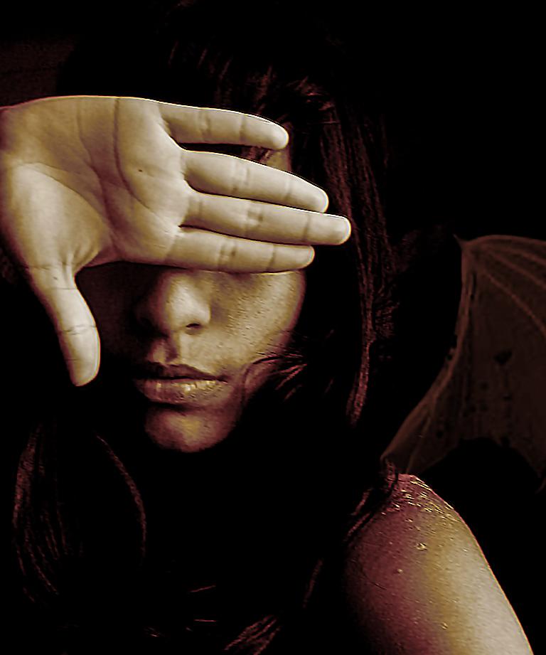 Kvinde dækker øjne med hånden