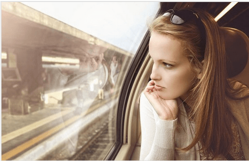 Kvinde ser ud af togvindue og tænker "du forlod mig"