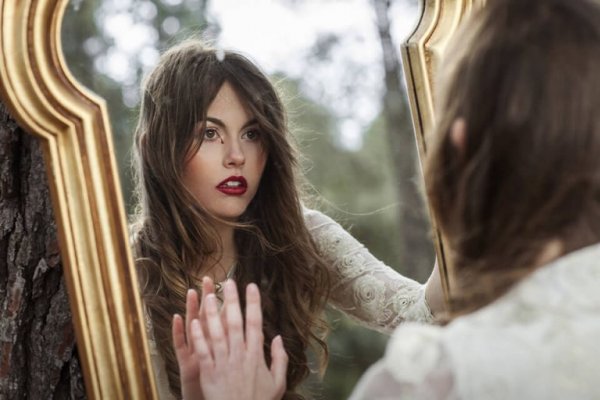 Kvinde ser sig selv i spejl for at anerkende sine ar