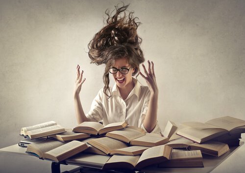 Kvinde med masser af bøger foran sig har stress