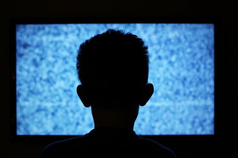 Mand ser tv i mørke