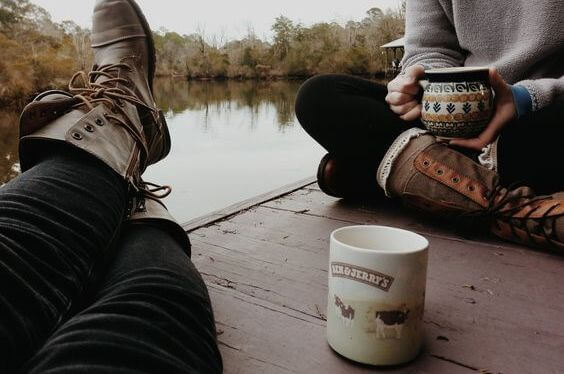 To venner drikker kaffe sammen på en bro