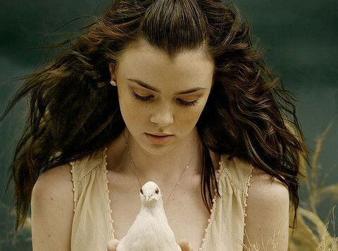 Kvinde holder fugl i hænderne