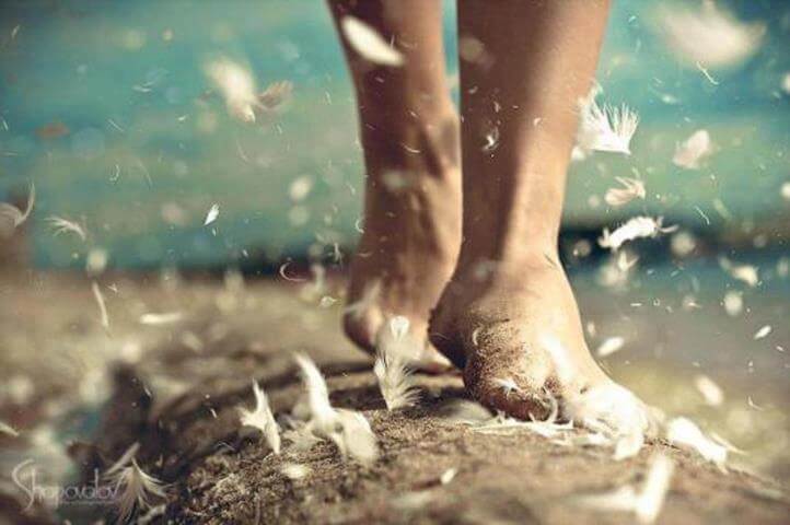 Person går med bare fødder på vej med flyvende fjer