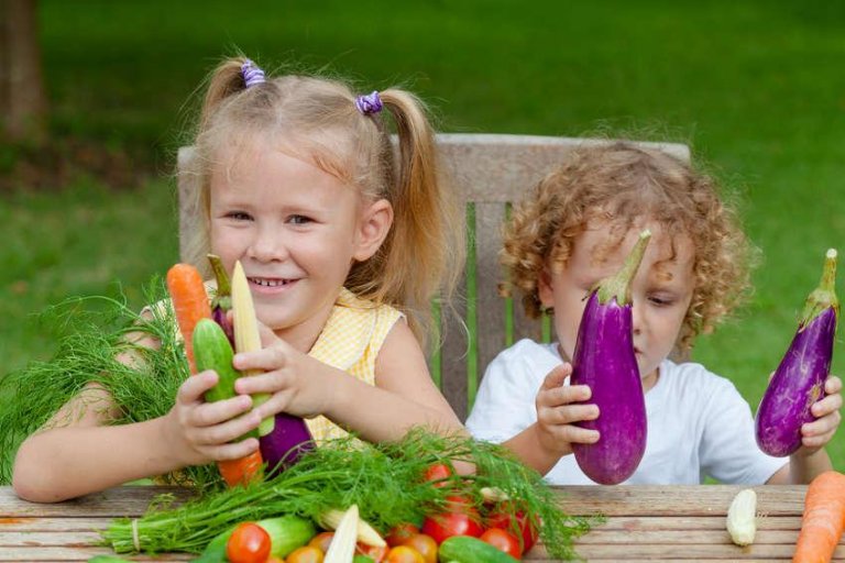 Børn sidder med grøntsager, som er superfoods