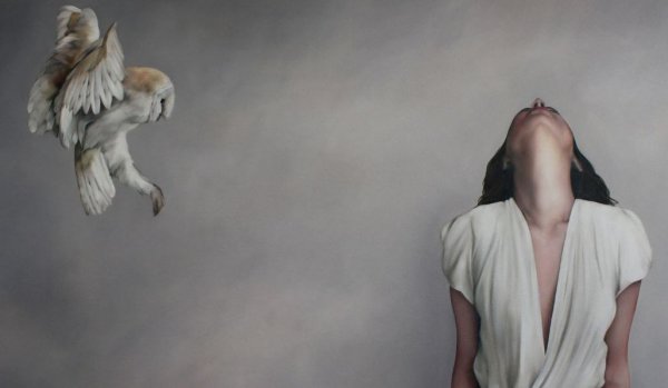 Kvinde foran grå væg med fugl tænker over sandheden om livet