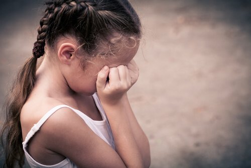 Barn græder og holder sig for øjnene på grund af barndomsdepression