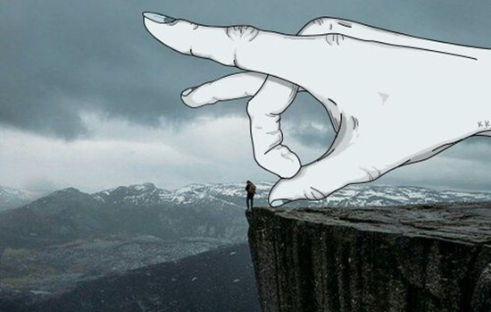 Hånd er ved at skubbe lille mand ned fra klippe