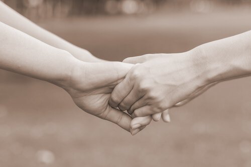 To personer holder i hånd som tegn på tilgivelse