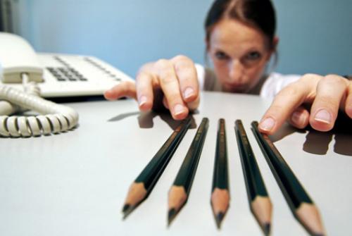 Kvinde lægger blyanter perfekt, da hun er fanget i et fængsel af perfektion