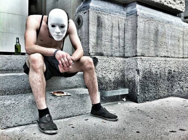 Mand bærer maske som en forklædning af alkoholisme