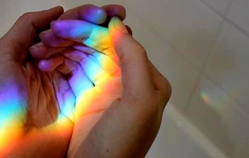 Person holder regnbue i sin hånd
