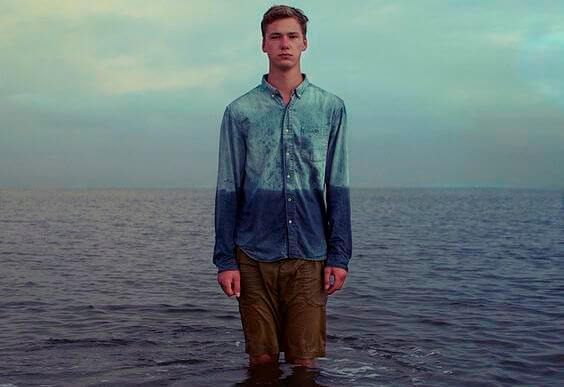 Mand foran hav på strand