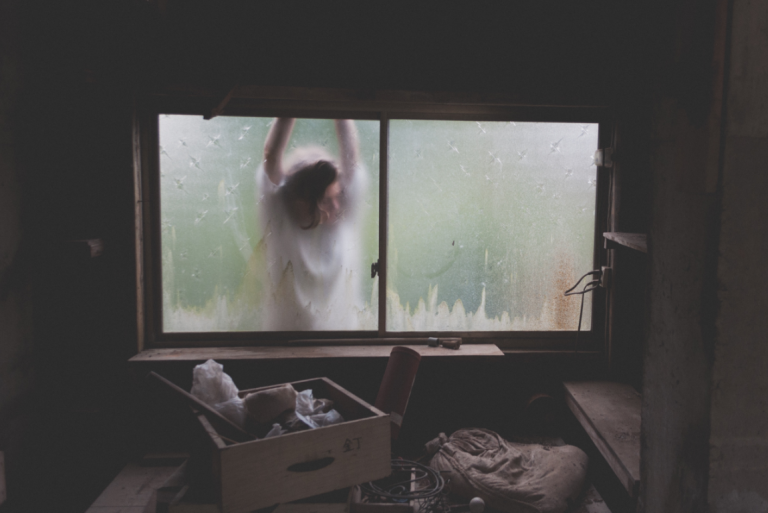 Person udenfor vindue er trist på grund af dysthymi