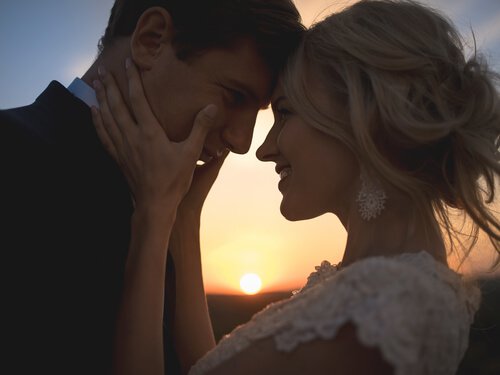 Nygift par nyder kærlighed foran solnedgang