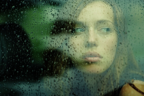 trist kvinde ser ud af vindue. At værdsætte livet