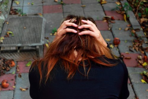 Kvinde tager sig selv til hovedet på grund af angst forårsaget af OCD
