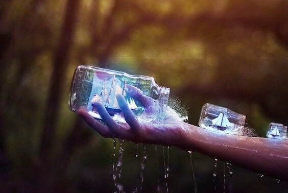 Person holder skibe i flasker på arm