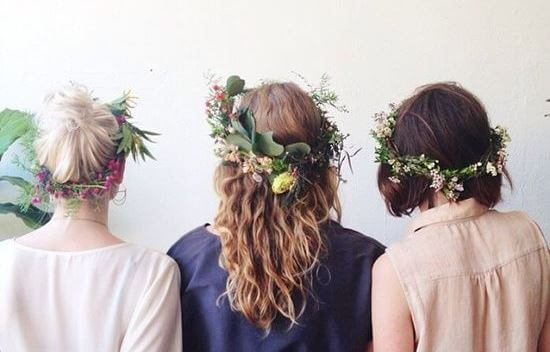 Veninder står med blomsterkranser i håret
