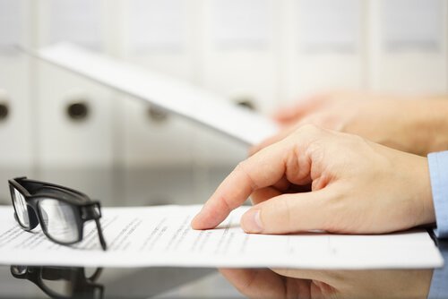 Mand ved skrivebord med papir er ved at snakke om chikane på arbejdspladen