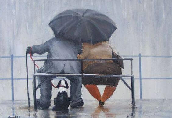 Ældre par sidder på bænk i regnvejr med paraply