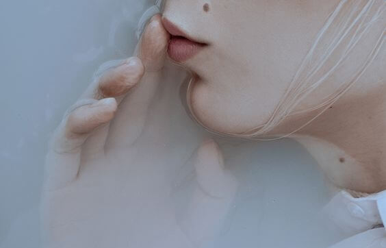 Kvinde sætter finger for mund for at bruge stilhed som afstraffelse