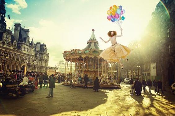 Kvinde til karneval bliver løftet til vejrs af balloner