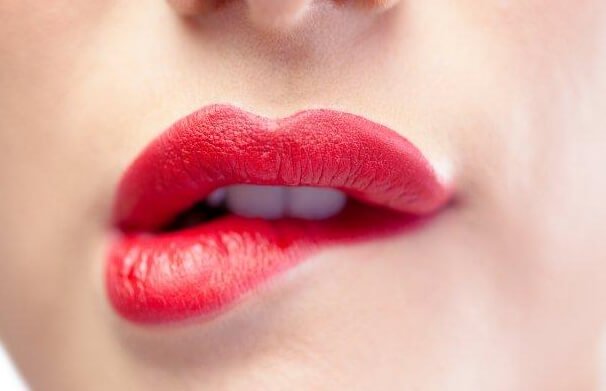 Kvinde bider sig selv i læbe for at udtrykke en særlig form for kropssprog