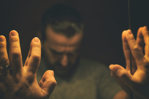 Trist mand med hænder på spejl ønsker at tage benzodiazepiner