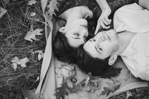 Par ligger på græs og er romantiske