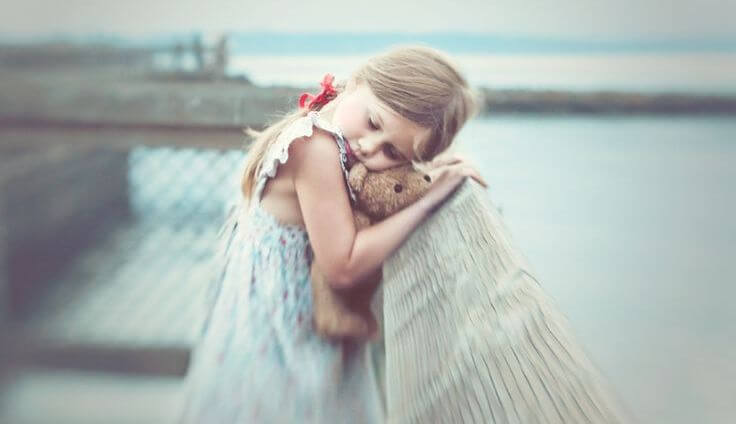 Lillepiger med mærker fra barndommen krammer bamse