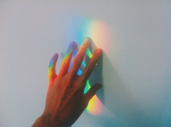 Hånd rører ved regnbue på væg og symboliserer, hvordan særligt sensitive mennesker opfanger små detaljer