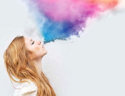 Kvinde puster farvet røg op i luften