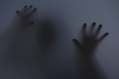Skygge af person med hænder på vindue er plaget af epidemi af angst