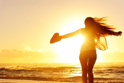 Fri kvinde på strand for solnedgang