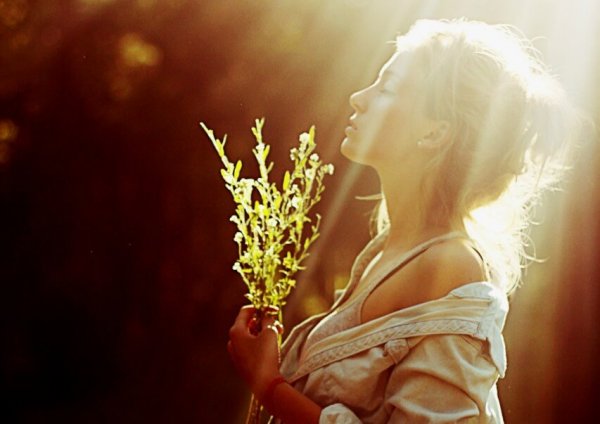 Kvinde i sollys med blomster