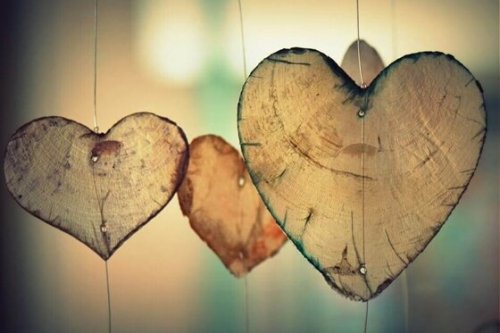 Hjerter lavet af træstamme hænger foran vindue