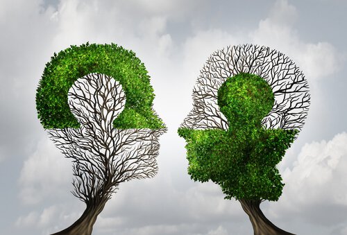 To træer formet som hoveder og puslespil viser, hvordan man kan fuldende hinanden ved at sætte sig selv i andres sted